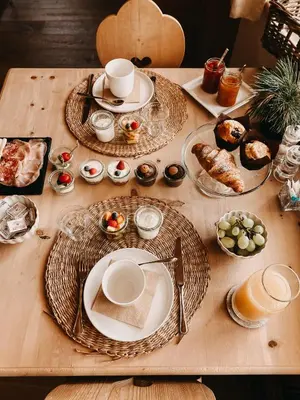 a wooden table with plates of food on it at Mountain Chalet Pra Ronch in Selva di Val Gardena