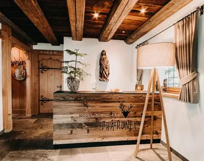 a room with a wooden table and a lamp at Mountain Chalet Pra Ronch in Selva di Val Gardena