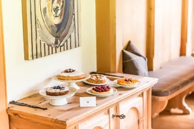 a table with four cakes on plates on it at Mountain Chalet Pra Ronch in Selva di Val Gardena