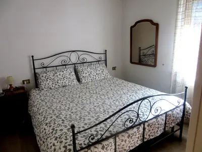 a bedroom with a bed with a black frame and a mirror at Gal28 in Predazzo