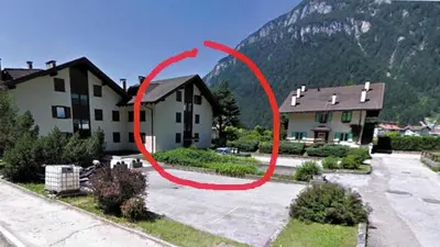 a living room with a couch and a kitchen with a table at Gal28 in Predazzo