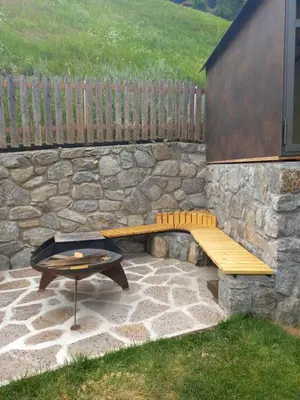 a stone wall with a bench and a table at Ferienhaus/Chalet in der Blaiche in San Leonardo in Passiria