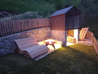 a fire pit with a bench in a backyard at Ferienhaus/Chalet in der Blaiche in San Leonardo in Passiria