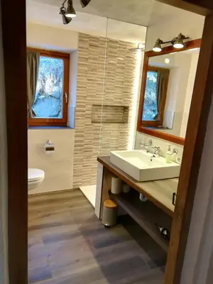a bathroom with a sink and a toilet and a mirror at Ferienhaus/Chalet in der Blaiche in San Leonardo in Passiria