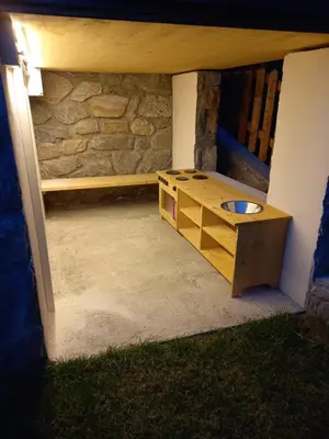 a dog house with a bench and a dog bowl at Ferienhaus/Chalet in der Blaiche in San Leonardo in Passiria