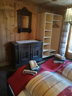 a room with a stove and two beds in it at Ferienhaus/Chalet in der Blaiche in San Leonardo in Passiria