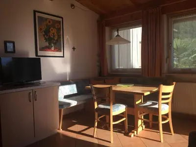 a living room with a table and chairs and a television at Weingut Zundlhof in Bolzano