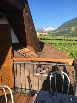 a deck with a fence and a table and chairs at Weingut Zundlhof in Bolzano