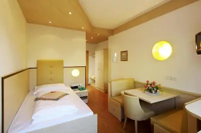 a hospital room with a bed and a table at Hotel Anatol in Merano