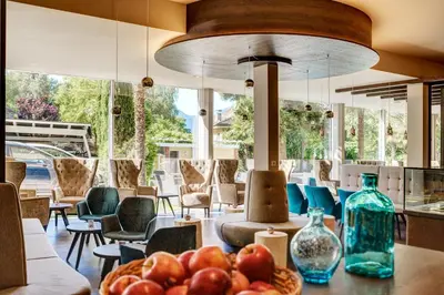 a room with chairs and a table with fruit on it at Hotel Anatol in Merano