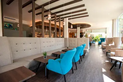 a restaurant with blue chairs and tables at Hotel Anatol in Merano