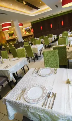 a dining room with tables and chairs with plates and silverware at Hotel Anatol in Merano