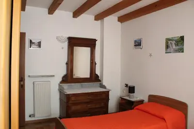 a bedroom with a bed and a dresser and a mirror at Appartamento Widmann in Coredo