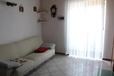 a living room with a couch and a clock on the wall at Appartamento Widmann in Coredo