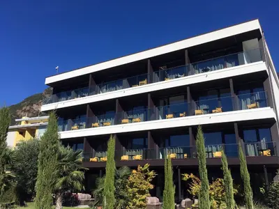 a large white building with tables and chairs at Hotel Raffl in Bolzano