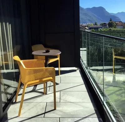 a balcony with a table and chairs on it at Hotel Raffl in Bolzano