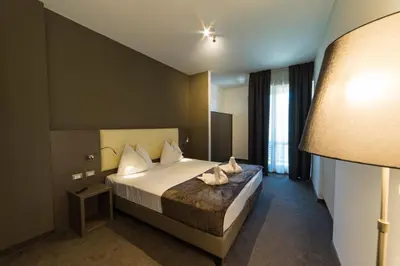 a hotel room with a bed and a lamp at Hotel Raffl in Bolzano