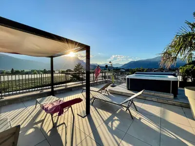 a deck with two chairs and a swimming pool at Hotel Raffl in Bolzano