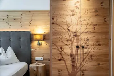 a bedroom with a large bed and a large window at Niederthalerhof Chalets in Bressanone