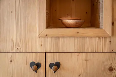 a small room with a bed in a wooden wall at Niederthalerhof Chalets in Bressanone