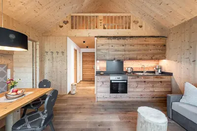 a room with two beds in a wooden cabin at Niederthalerhof Chalets in Bressanone