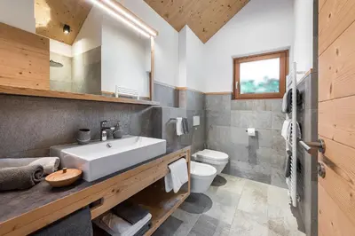 a kitchen and living room of a log cabin at Niederthalerhof Chalets in Bressanone