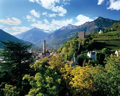 a town on a hill with mountains in the background at Hotel Schönbrunn in Merano