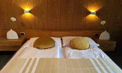 a bed with two pillows and two vases on the wall at Hotel Schönbrunn in Merano
