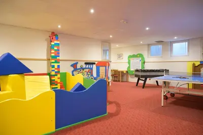 a childrens play room with a ping pong table at Glanzhof Hotel & Apartments in Marlengo