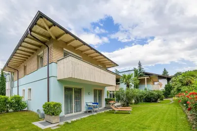 a house with a green yard with a bench at Glanzhof Hotel & Apartments in Marlengo