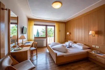 a hotel room with a bed and a desk and a desk at Glanzhof Hotel & Apartments in Marlengo