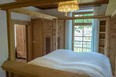 a bedroom with a bed in a room with a window at Schlosswirt Forst in Lagundo