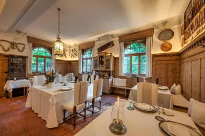 a dining room with white tables and chairs and windows at Schlosswirt Forst in Lagundo