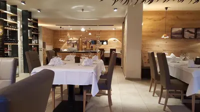 a dining room with white tables and chairs at Hotel Kranebitt in Val di Vizze