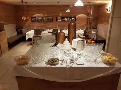 a table with wine glasses on it in a restaurant at Hotel Kranebitt in Val di Vizze