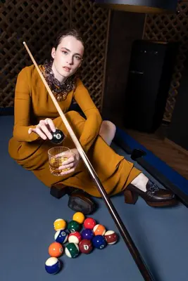 a woman sitting on the floor next to a pool table at Linder Cycling Hotel in Selva di Val Gardena