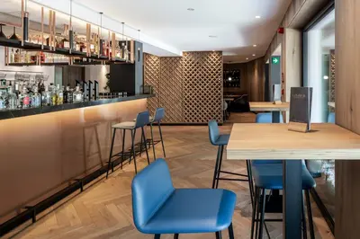 a bar with blue chairs and a wooden table at Linder Cycling Hotel in Selva di Val Gardena