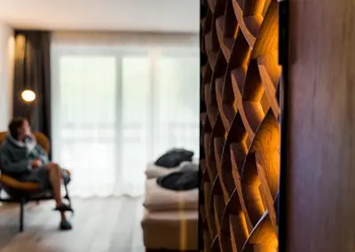 a man sitting in a chair in a room at Linder Cycling Hotel in Selva di Val Gardena