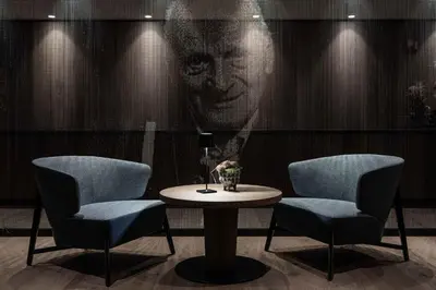 a table with two chairs and a picture of a man at Linder Cycling Hotel in Selva di Val Gardena
