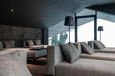 a living room with two couches and large windows at Linder Cycling Hotel in Selva di Val Gardena