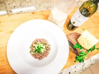 a plate of food on a table with a bottle of wine at Pension Maria in Antermoia