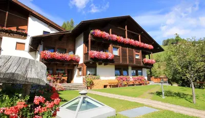 a house with flower boxes on the front of it at Pension Maria in Antermoia