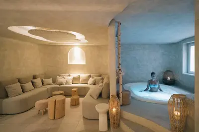 a room with a tub with a man sitting in it at Garni Aritz in Campitello di Fassa
