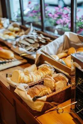 a table topped with baskets of bread and pastries at Garni Aritz in Campitello di Fassa