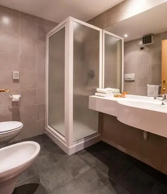 a bathroom with a shower and a sink and a toilet at Garni Aritz in Campitello di Fassa