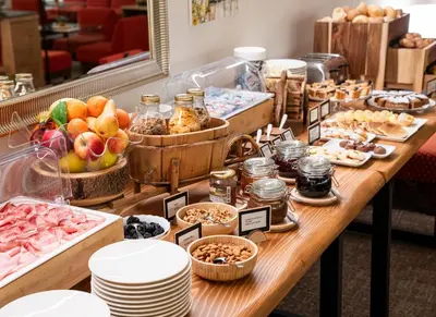 a buffet of food on a wooden table at Residence Lastei in San Martino di Castrozza