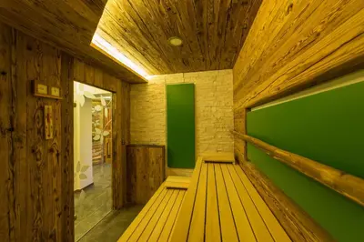 an empty room with a green wall and wooden floor at Hotel Ristorante Lewald in Bolzano