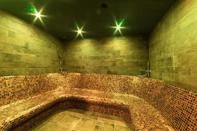 a bathroom with a large brick tub with lights at Hotel Ristorante Lewald in Bolzano