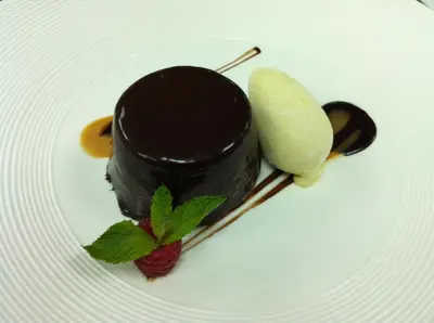 a piece of chocolate dessert on a plate with a strawberry at Hotel Ristorante Lewald in Bolzano