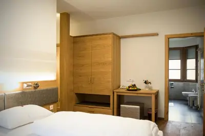 a bedroom with a bed and a desk and a sink at Hotel Ristorante Lewald in Bolzano